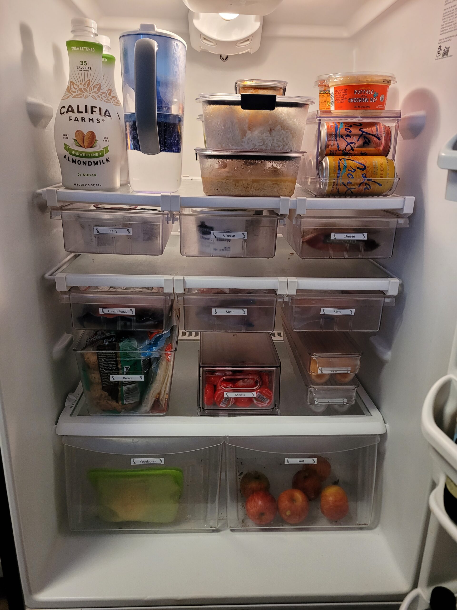 Refrigerator organized with bins and drawers all labeled and categorized