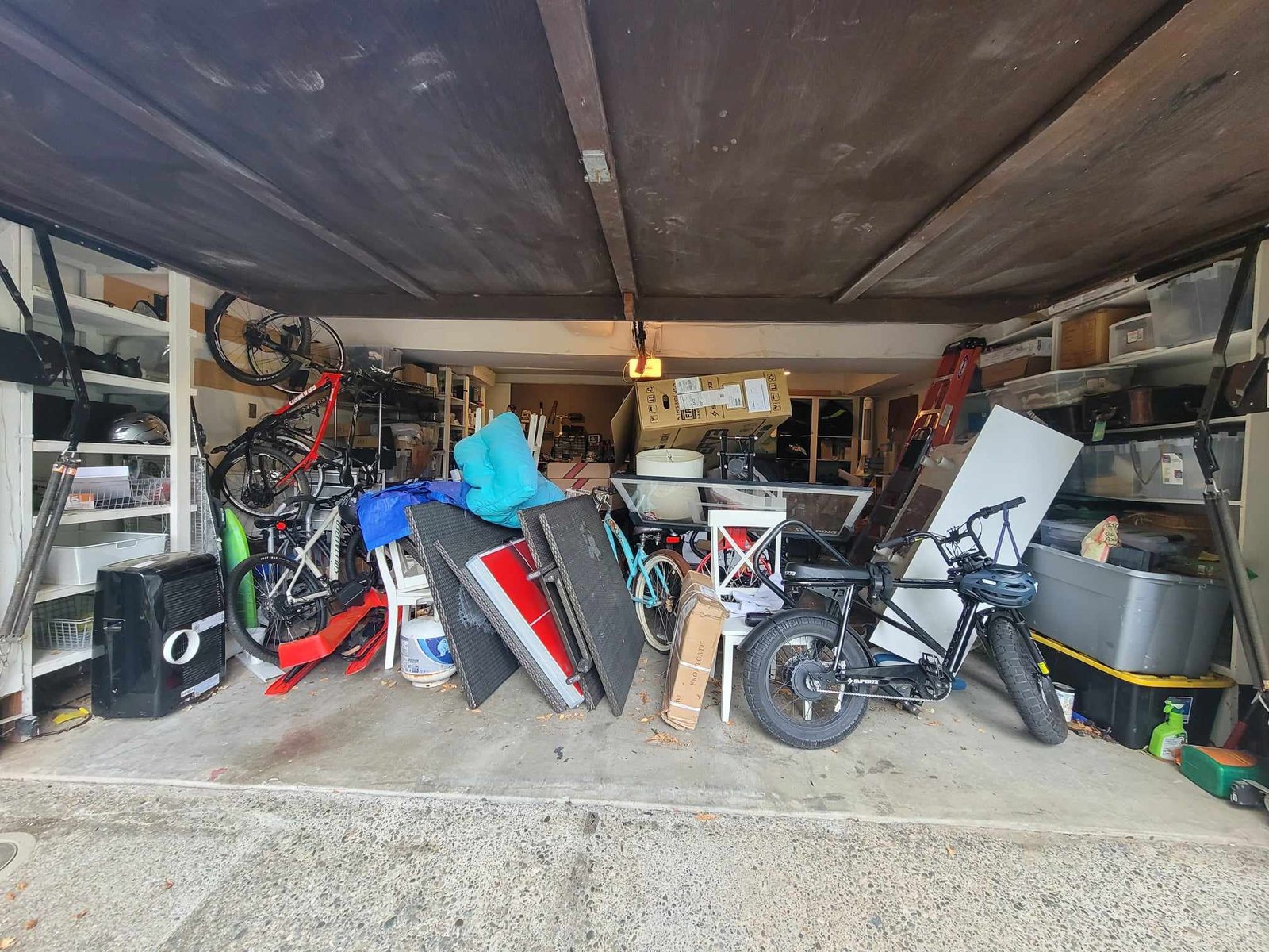 Before organization image of a garage with no walkway and stuff piled everywhere