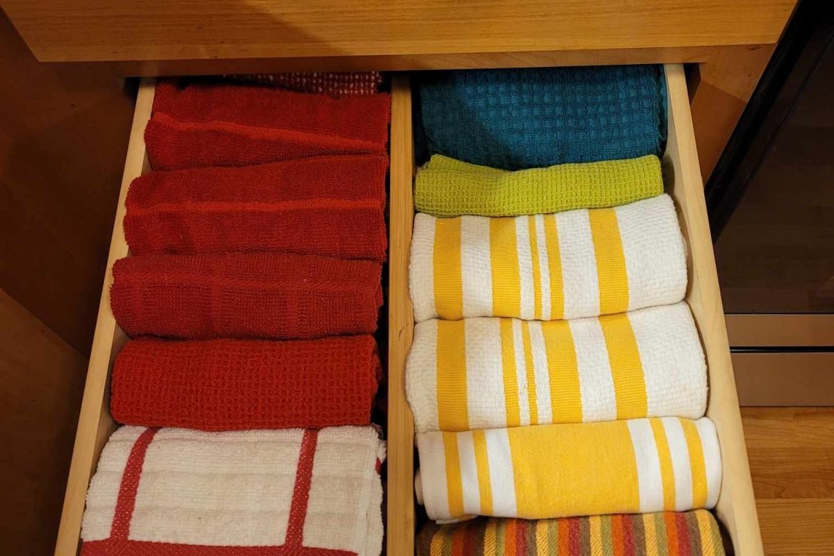 After organization image of kitchen towel drawer with towels file folded and divided with a bamboo drawer divider