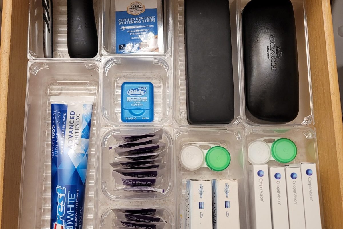 Bathroom drawer with dental, shaving, and vision care categorized into plastic drawer inserts