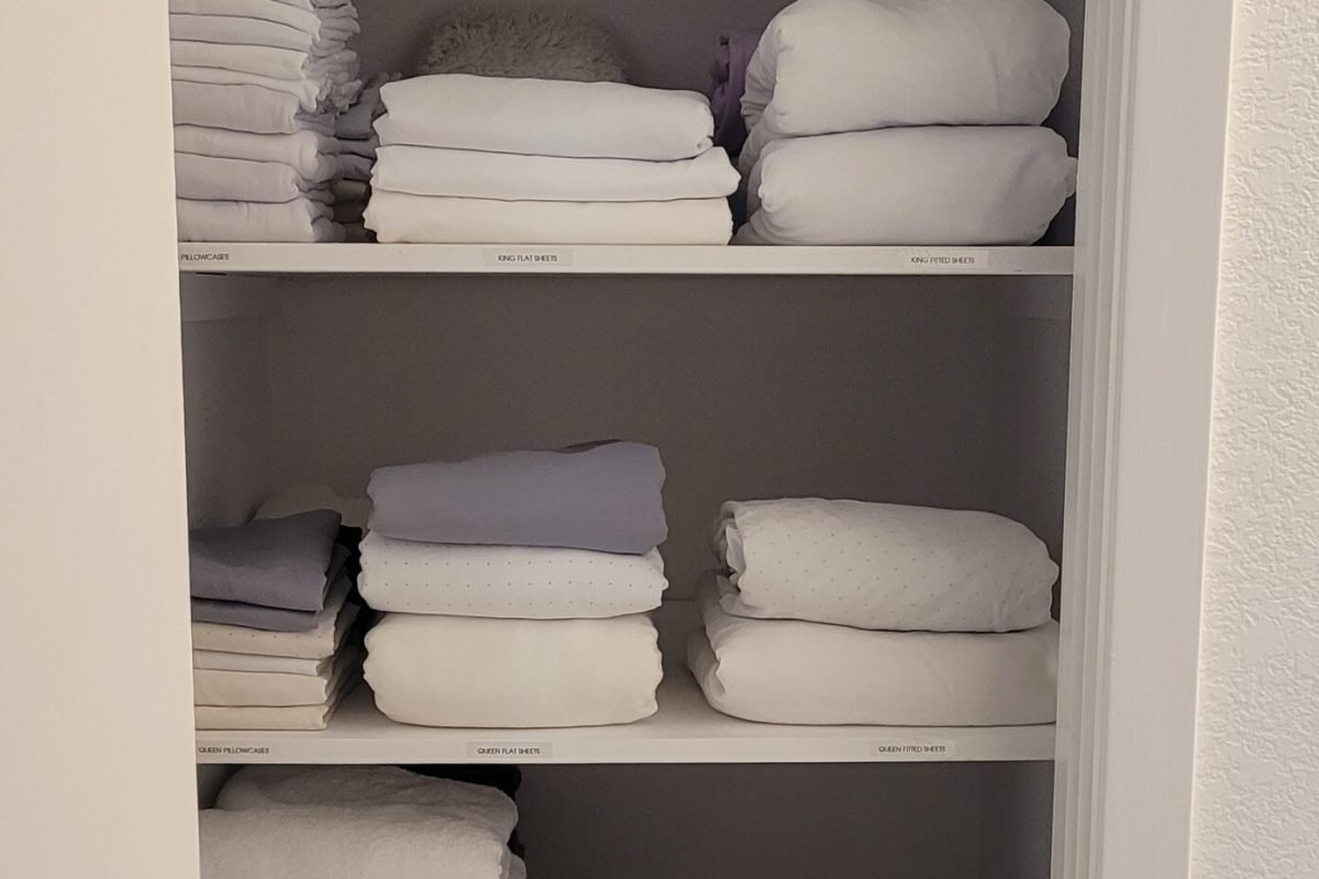 Linen Closet Organization with all linens neatly folded and shelves labeled for categories